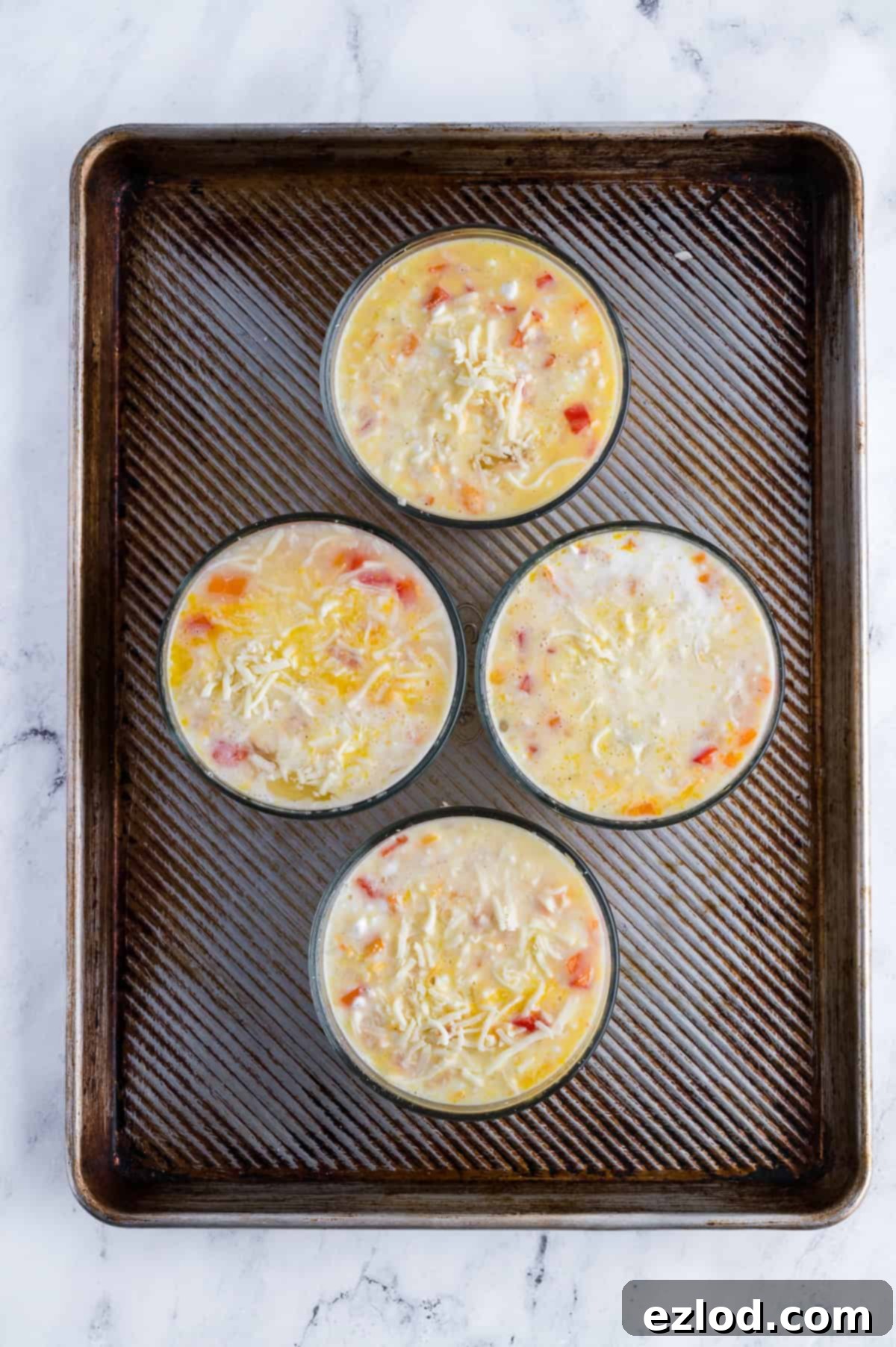 Breakfast bowls are placed on a baking sheet before being baked.