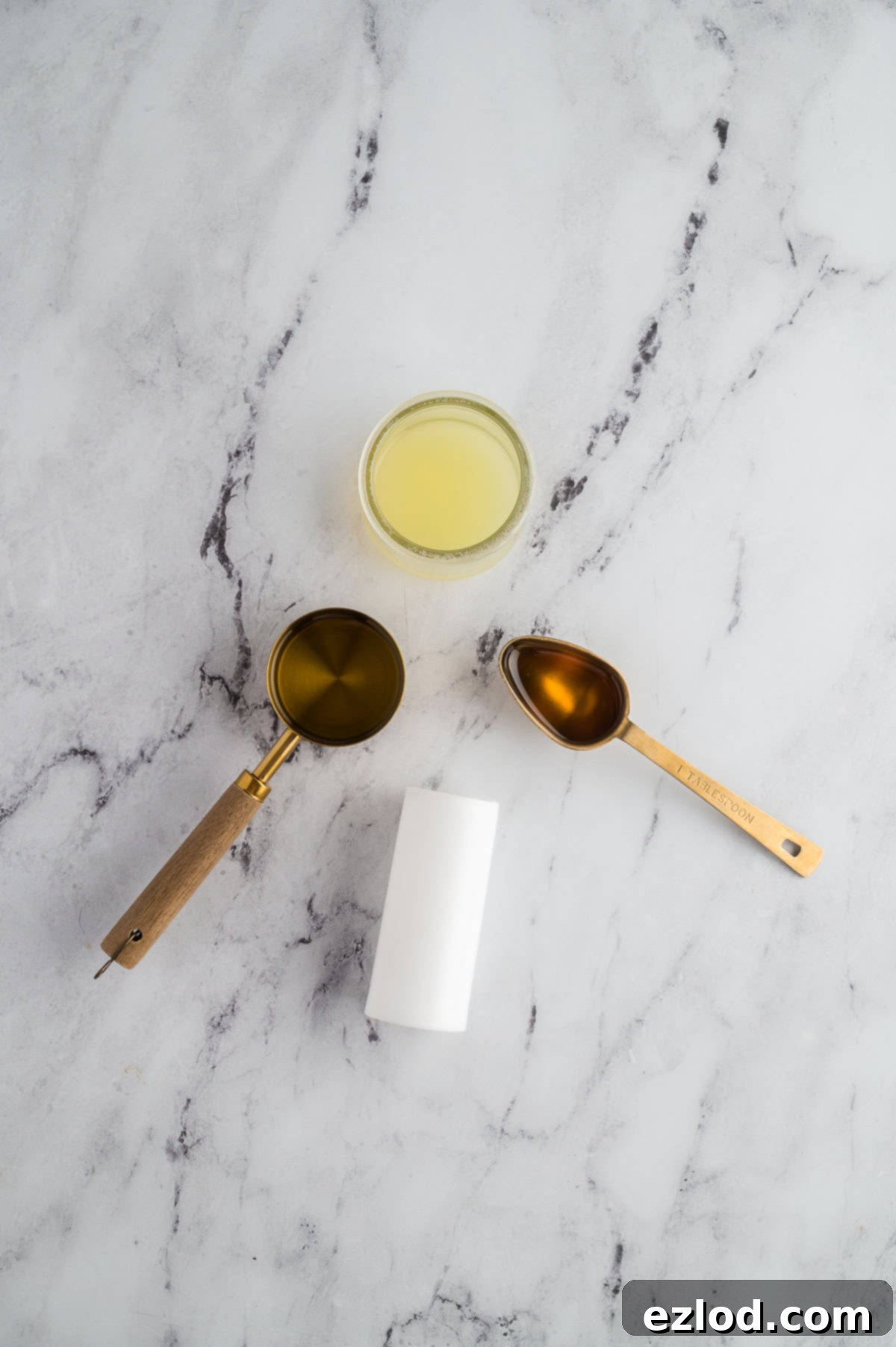 Lemon juice, olive oil, and honey measured out for a light dressing.
