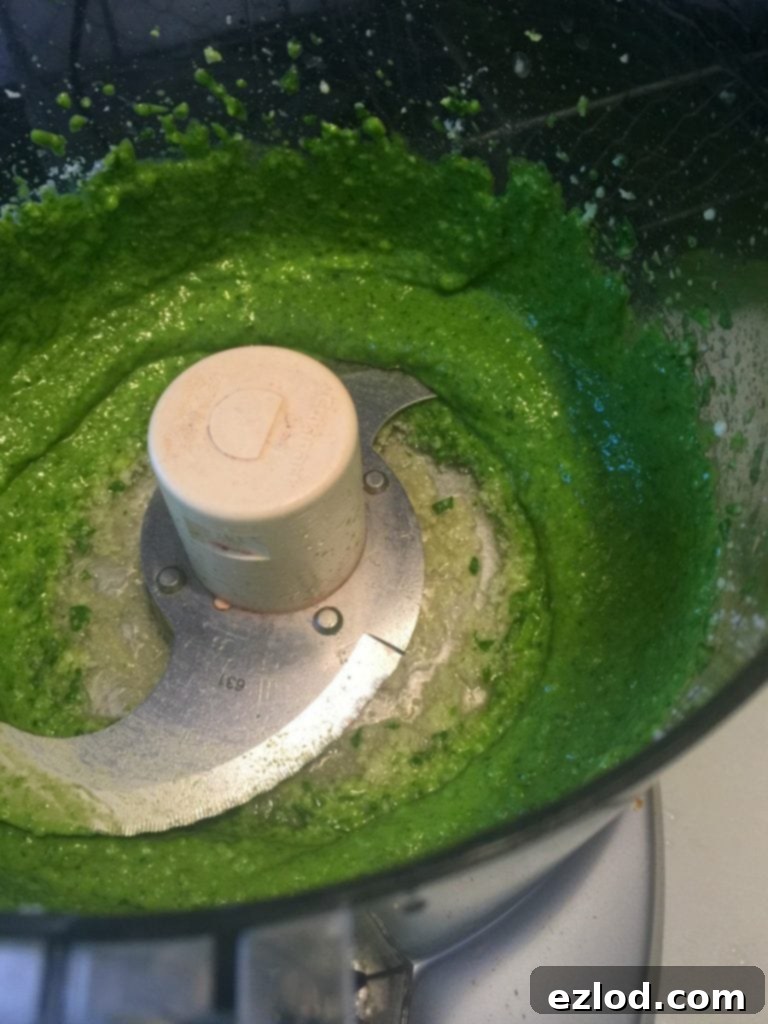 Effortless Spinach Pesto 3 Ingredients for spinach pesto in a food processor, highlighting the ease of preparation.