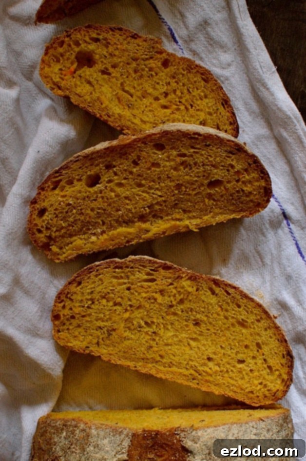 An appetizing close-up of a freshly baked carrot and caraway seed sandwich bread loaf, showing its soft interior and crust.