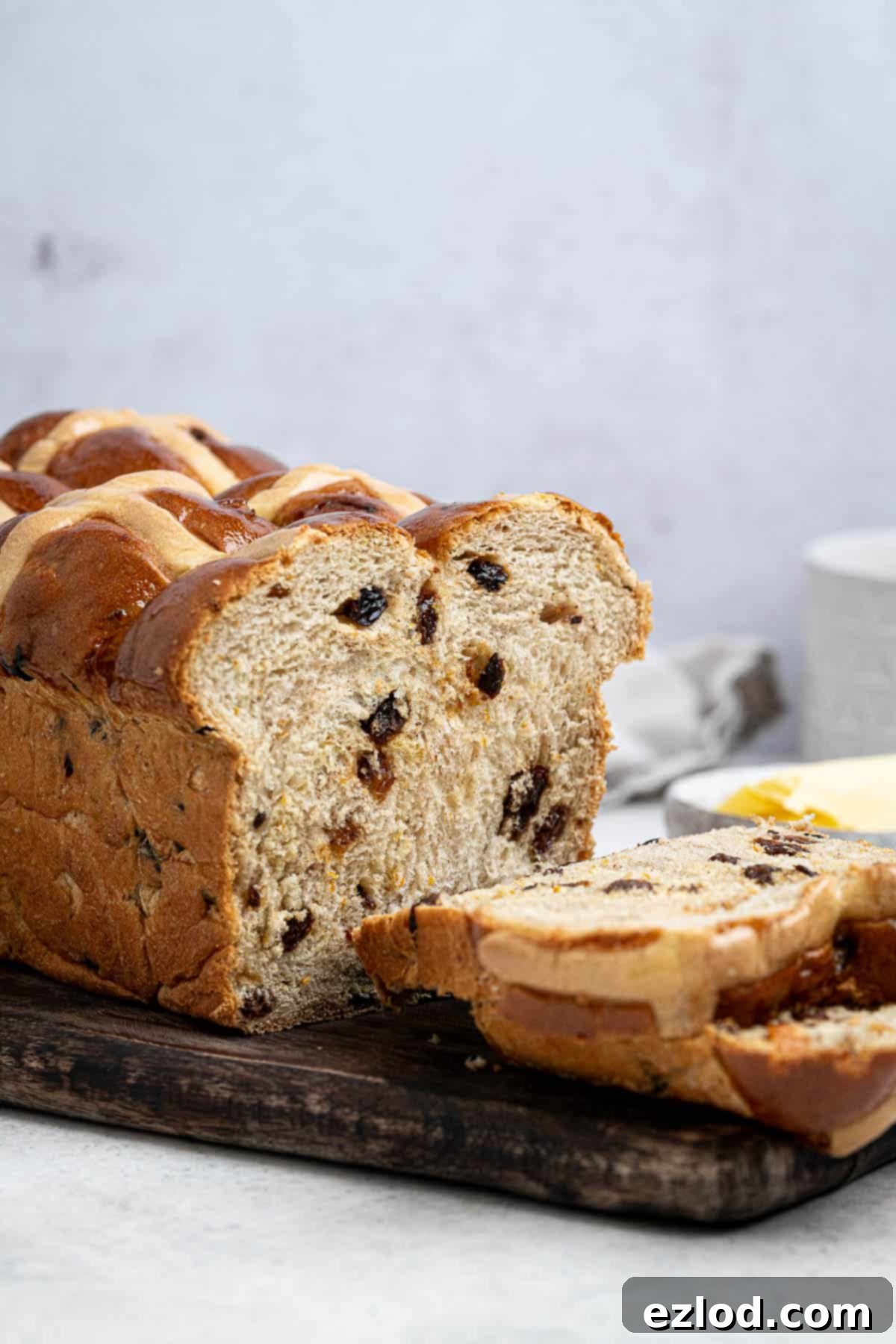 Vegan hot cross bun loaf on a wooden board.