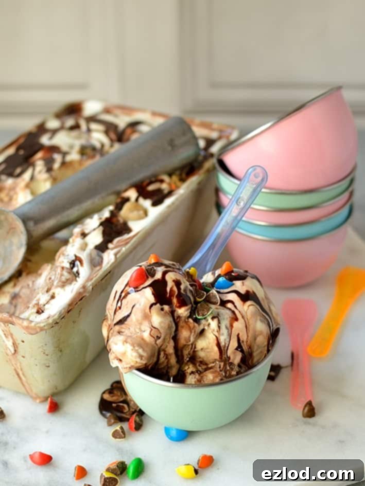 Easy, no-churn, three ingredient vanilla ice cream with M&M's cookie dough pieces and chocolate fudge swirl, close-up of the delicious layers