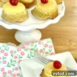Close up photo of a pineapple upside down cupcake on a white rectangular plate.