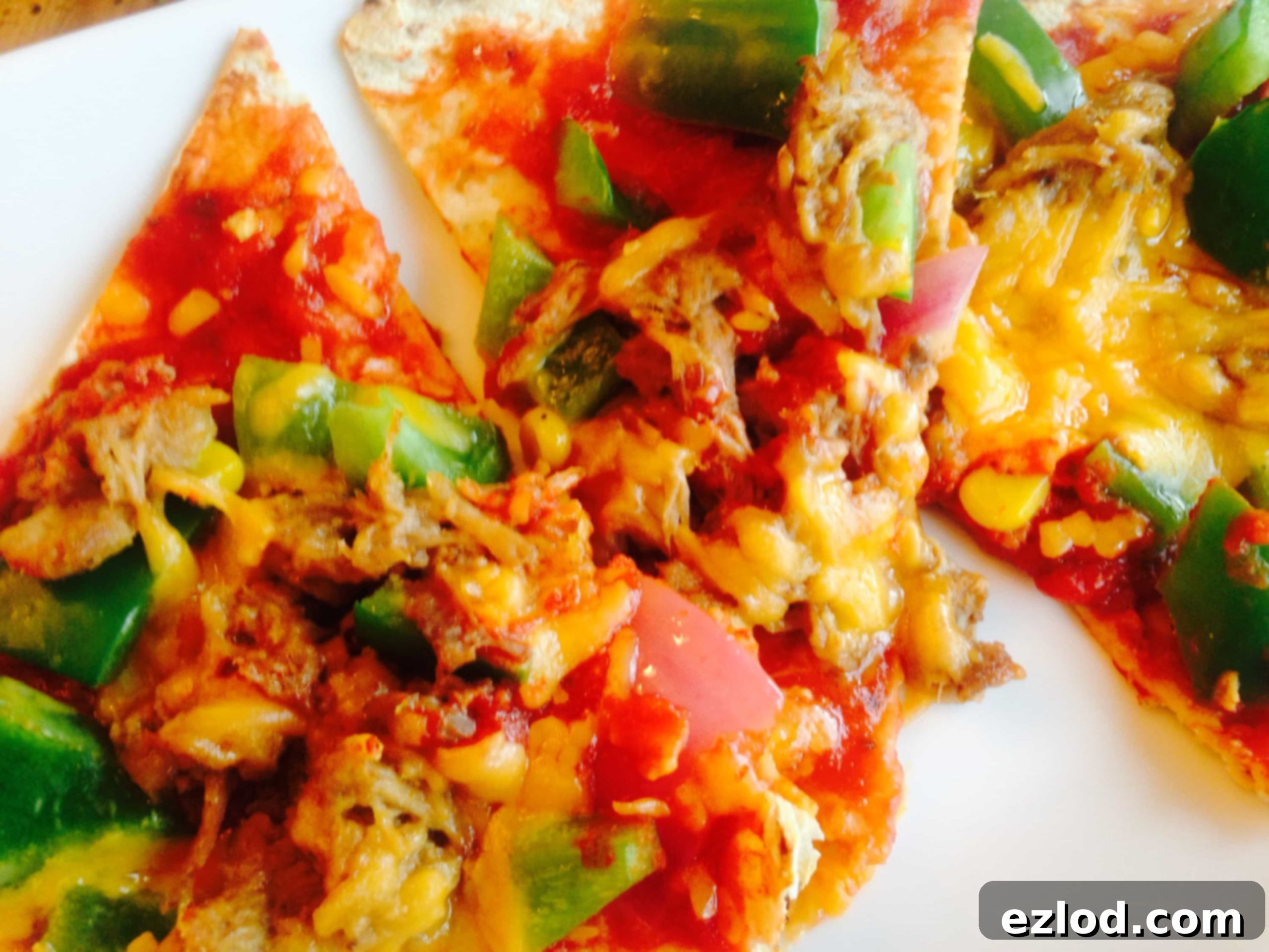 Delicious Pork Enchiladas Flatbread Pizza - a healthy comfort food, made with leftover pork carnitas, homemade enchilada sauce, fresh peppers, onions, and melted cheddar cheese. A perfect 21 Day Fix approved meal!
