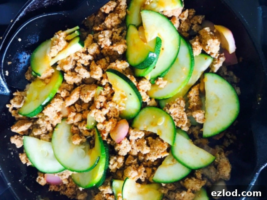 Full view of a Lazy Zucchini Enchilada Skillet in a cast iron pan, ready to be served, highlighting its easy, healthy appeal for 21 Day Fix.