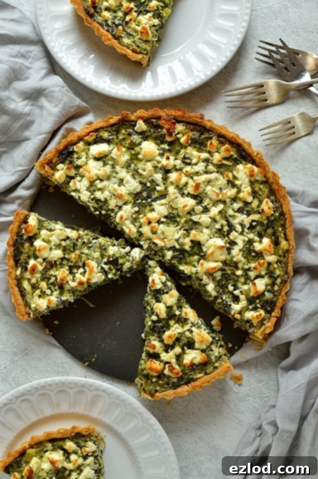 A close-up shot of a single slice of Spinach, Ricotta, and Feta Quiche, highlighting the creamy texture and flecks of green spinach and herbs.
