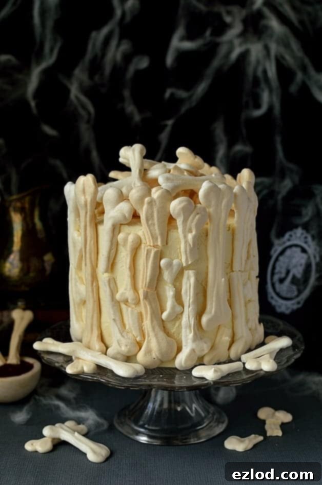 Meringue Bone Palace Halloween Cake - a grand and spooky dessert featuring a moist chocolate cake, vanilla Swiss meringue buttercream, and raspberry jam, decorated with delicate meringue bones and a berry coulis 'blood' drizzle