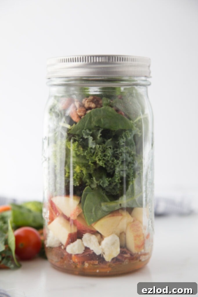 Two distinct Fall Harvest Mason Jar Salads, one featuring apple and turkey bacon, the other pear and diced chicken, highlighting versatile and delicious flavor combinations.