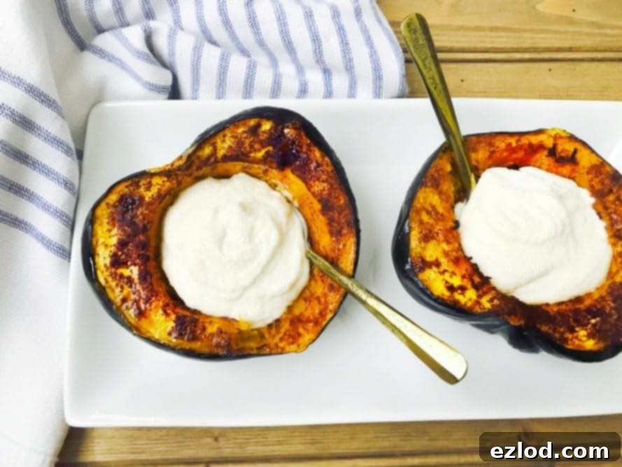 Two halves of a beautifully roasted acorn squash sit on a rectangular plate, generously stuffed with creamy sweet maple whipped ricotta. Spoons are ready in each half, inviting you to dig into this healthy and delicious treat.