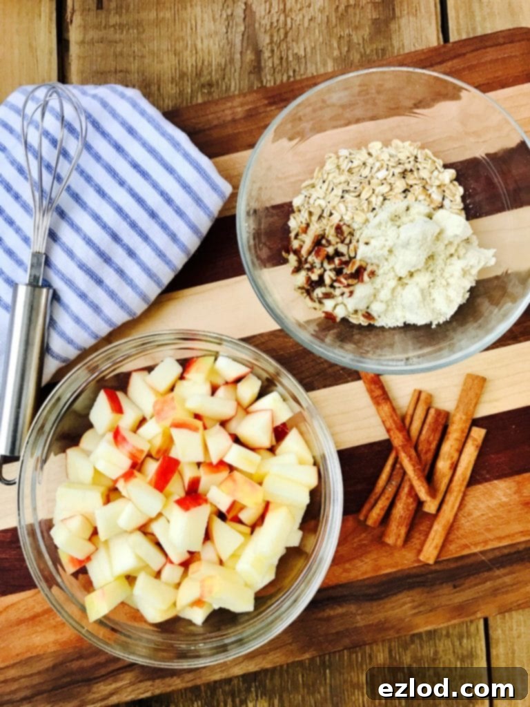 A bowl of apples and oats on a wooded cutting board - ingredients for Instant Pot Apple Crisp