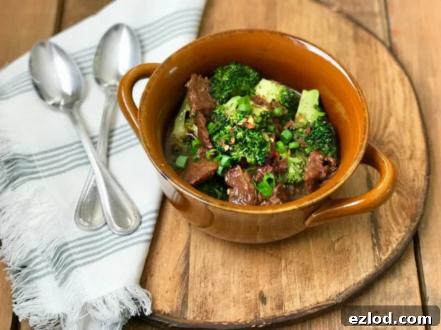 Instant Pot Beef and Broccoli served over white rice, garnished with scallions and red pepper flakes.