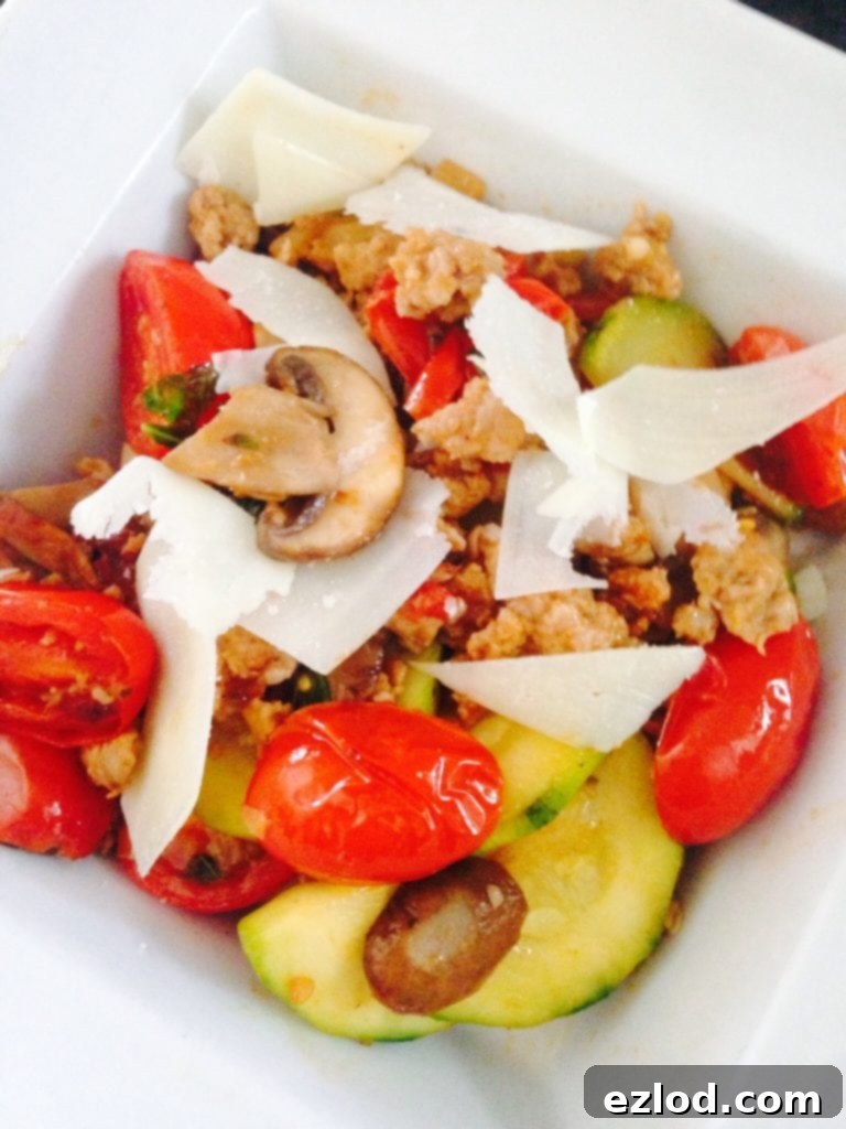 Spicy Sausage & Roasted Vegetable Medley 2 Spicy Sausage cooked with mushrooms, grape tomatoes, and zucchini and topped with shaved parmesan cheese in a white square bowl