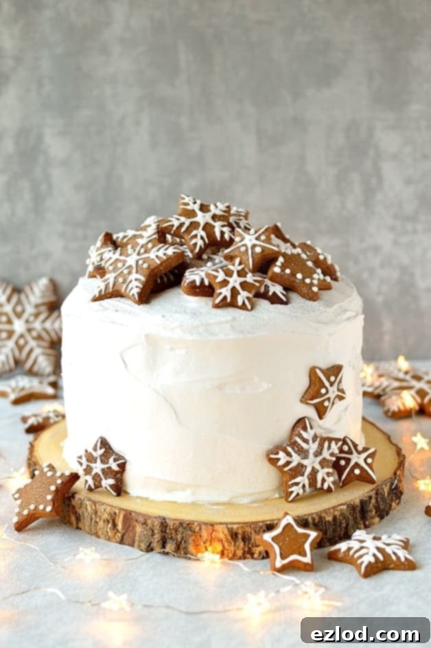Rich Christmas fruitcake topped with marzipan, royal icing and gingerbread stars and snowflakes, showcasing festive elegance.