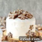 Rich Christmas fruitcake topped with marzipan, royal icing and gingerbread stars and snowflakes, a delightful holiday dessert.