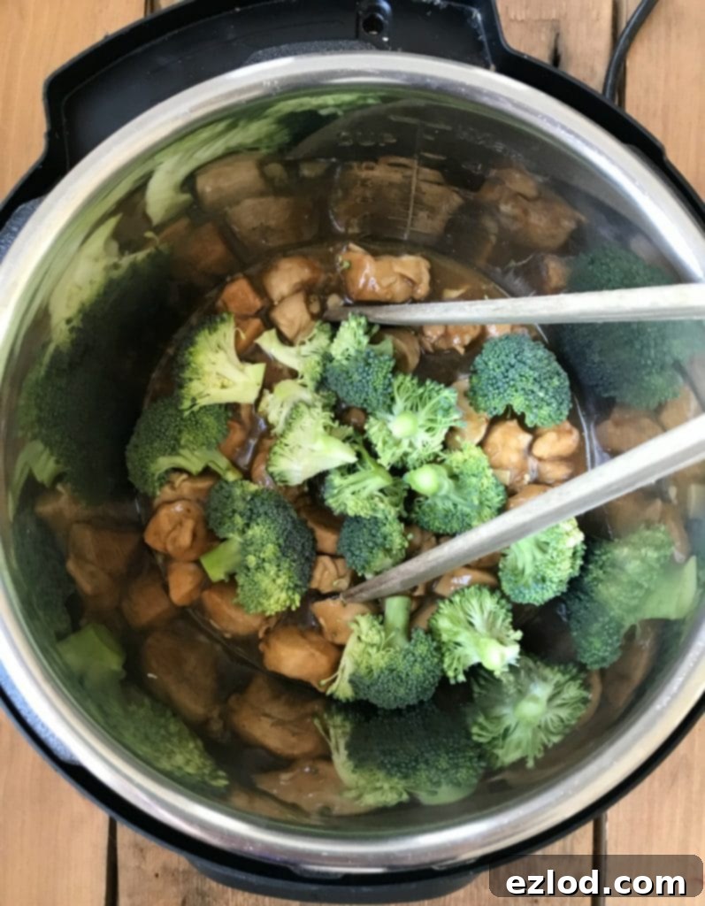 Overhead shot of Instant Pot Chicken and Broccoli in the Instant Pot liner, with steam rising gently after cooking.