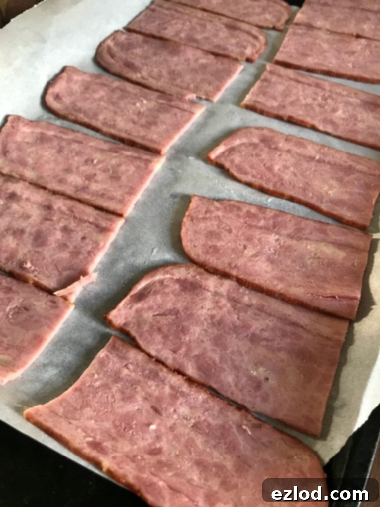 Turkey bacon laid out on a parchment-lined baking sheet