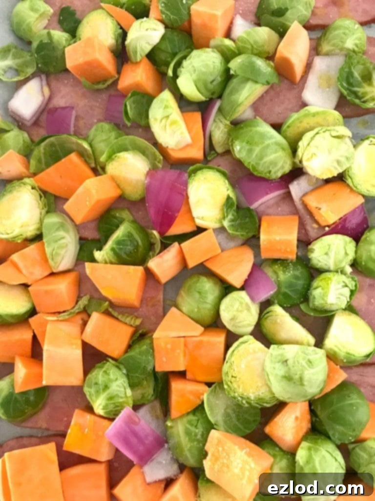 Sheet pan with breakfast ingredients halfway through cooking