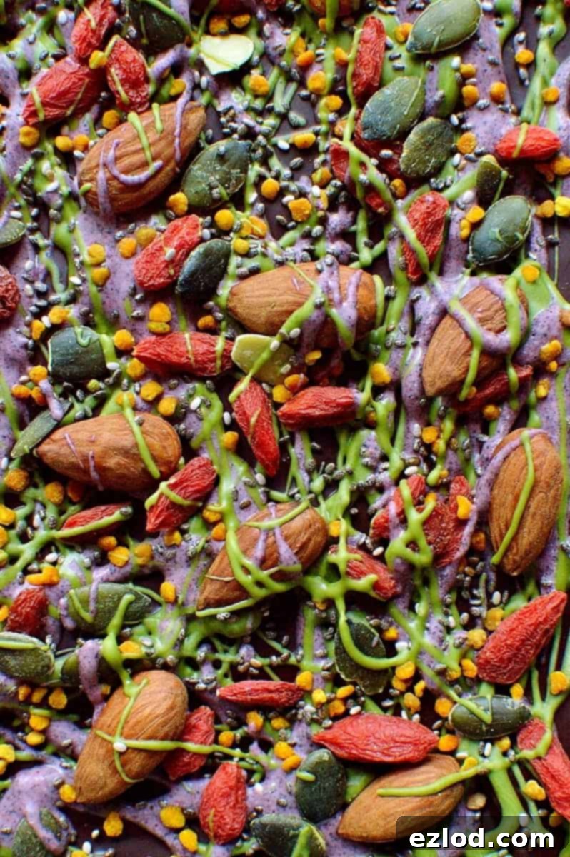 Superfood chocolate bark - dark chocolate topped with almonds, goji berries, seeds, bee pollen and white chocolate flavoured with matcha and freeze dried blueberry powder