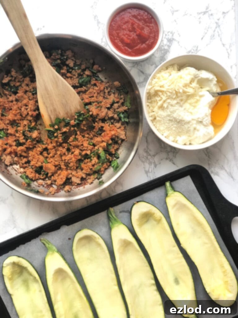 A vibrant array of prepared ingredients, including perfectly sautéed ground meat with spinach, a rich and creamy cheese mixture, and flavorful marinara sauce, all meticulously arranged and ready to be layered into hollowed zucchini for homemade Zucchini Lasagna Boats.