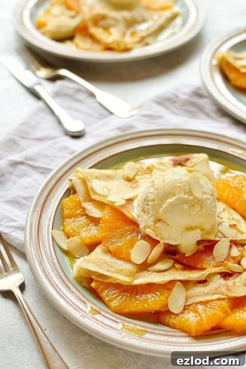 A close-up shot of the caramel oranges and almond ice cream on delicate crepes, showcasing the textures.