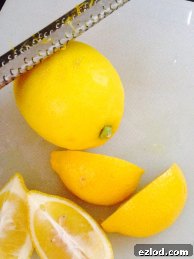 Lemons and lemon wedges being zested with a Microplane