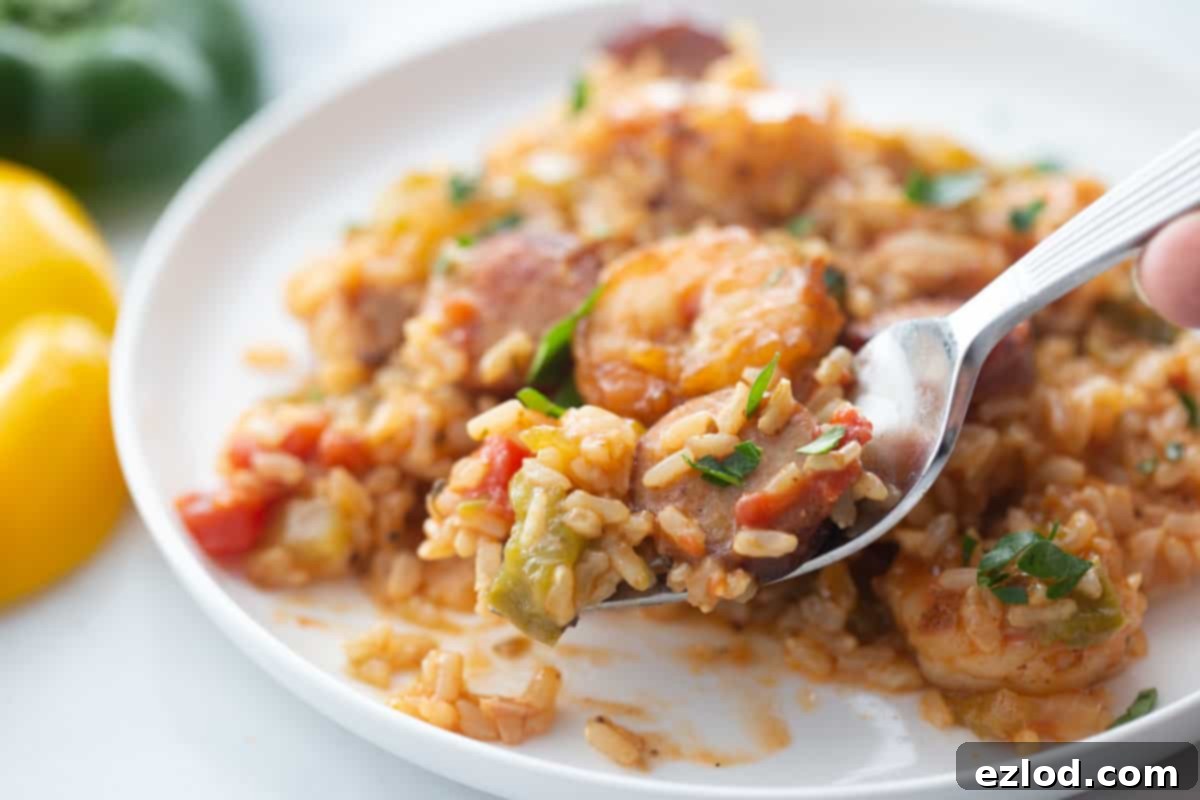 A forkful of healthy Instant Pot Jambalaya with yellow and green bell peppers nearby.