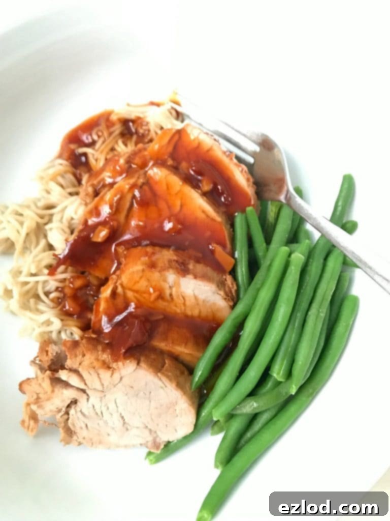 Instant Pot Asian Pork Tenderloin plated with noodles and green beans - a healthy and delicious meal.