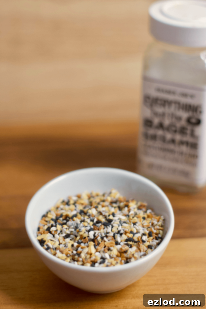 DIY Homemade Everything Bagel Seasoning in a clear jar with a wooden spoon, emphasizing fresh ingredients.