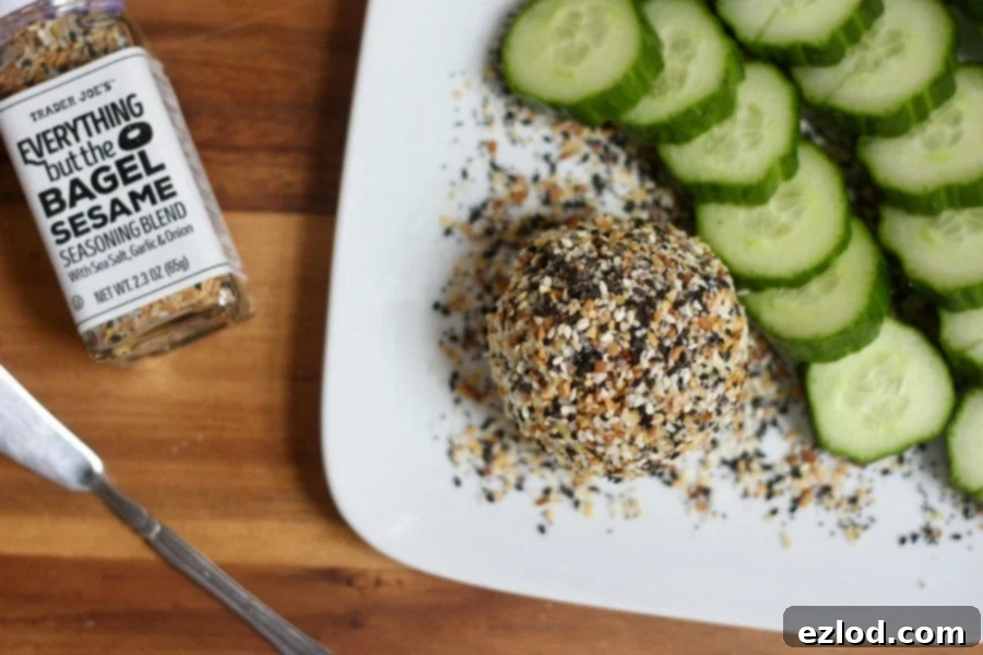 Everything Bagel Goat Cheese ball on a plate, ready to be served with fresh vegetables.