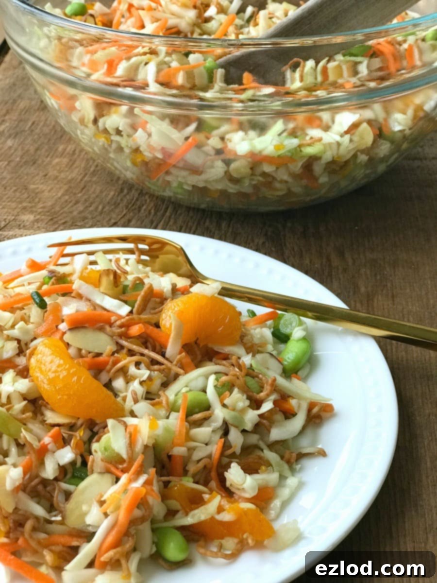 A small white plate of Ramen Noodle Salad next to a large glass bowl of Ramen Noodle Salad in the background