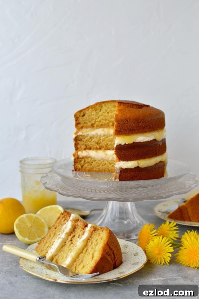 Vegan lemon curd layer cake with a slice taken out, showing the creamy lemon layers.