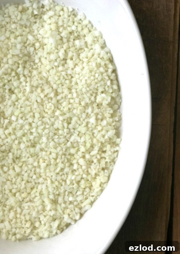 Casserole dish with cauliflower rice base layered with chicken and broccoli