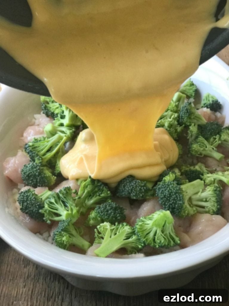 Cheese sauce being drizzled over broccoli and cheddar casserole