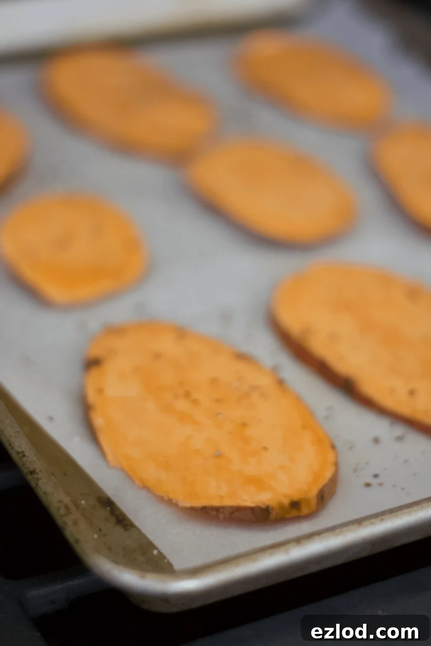 How to Meal Prep Sweet Potato Toast: Close-up of sweet potato slices on a cutting board, seasoned with sea salt and oil, demonstrating the slicing and seasoning process.