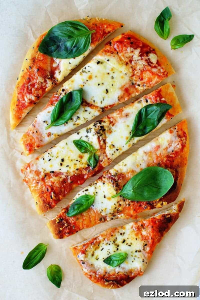 Delicious ten-minute naan pizza, topped with melted cheese and fresh basil, ready to eat.