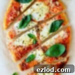 A small naan pizza thumbnail image, showing melted cheese and a sprinkle of basil.