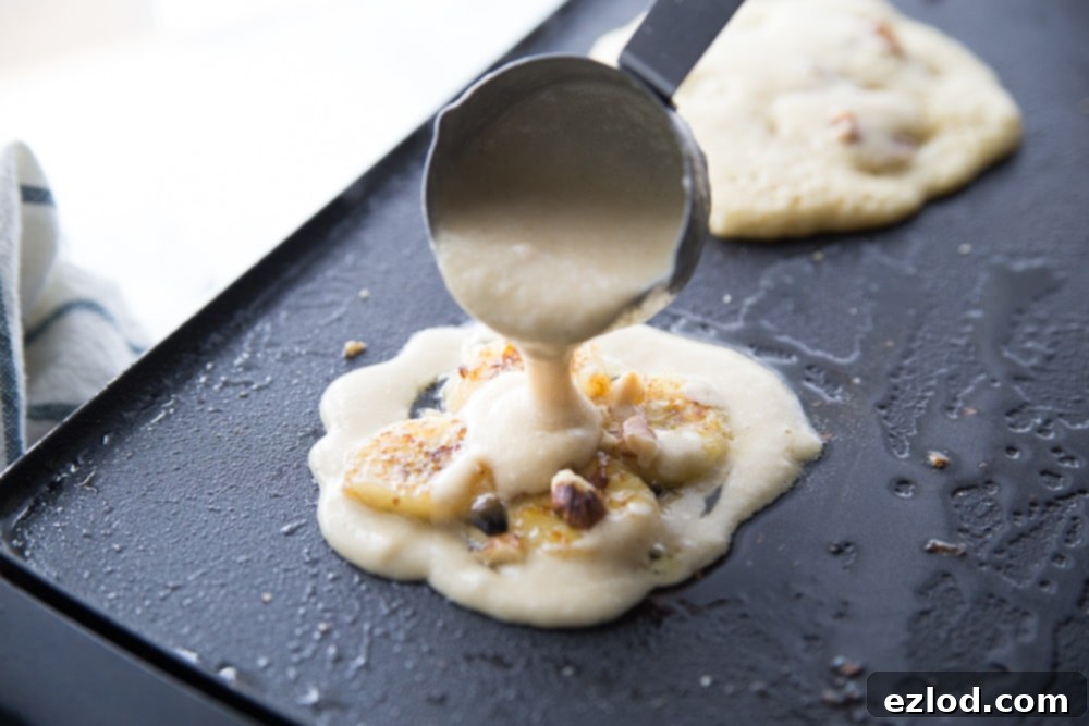 Sliced ripe bananas being caramelized in a pan with butter, preparing them for the pancake batter.