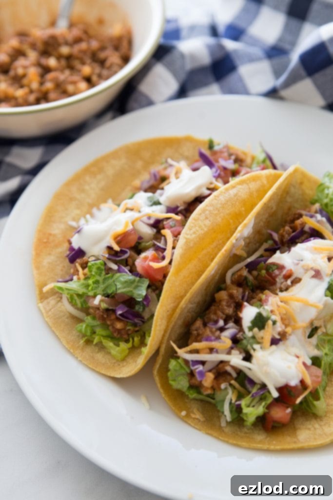 A serving of Hidden Cauliflower Taco Meat in a soft shell taco with fresh toppings.