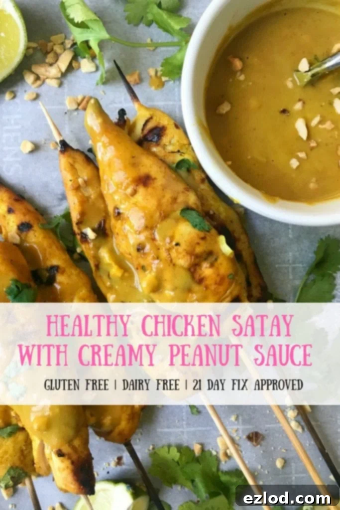 Grilled 21 Day Fix Chicken Satay with Creamy Peanut Sauce, garnished with cilantro and lime, on a rustic wooden board.
