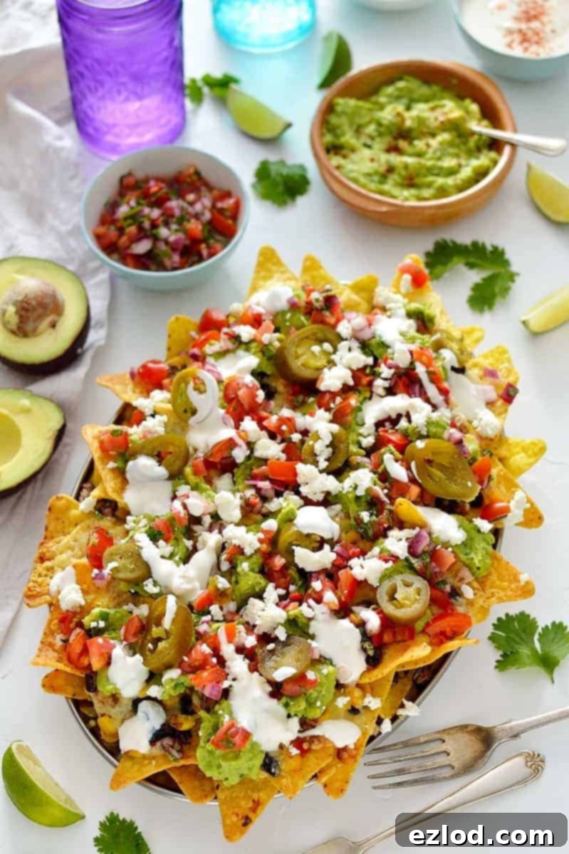 Loaded veggie nachos - topped with two kinds of beans, corn, salsa, guacamole, cheese and sour cream, this is the best way to eat a bag of chips for dinner!