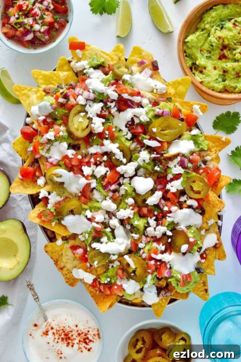 Loaded veggie nachos - topped with two kinds of beans, corn, salsa, guacamole, cheese and sour cream, this is the best way to eat a bag of chips for dinner!