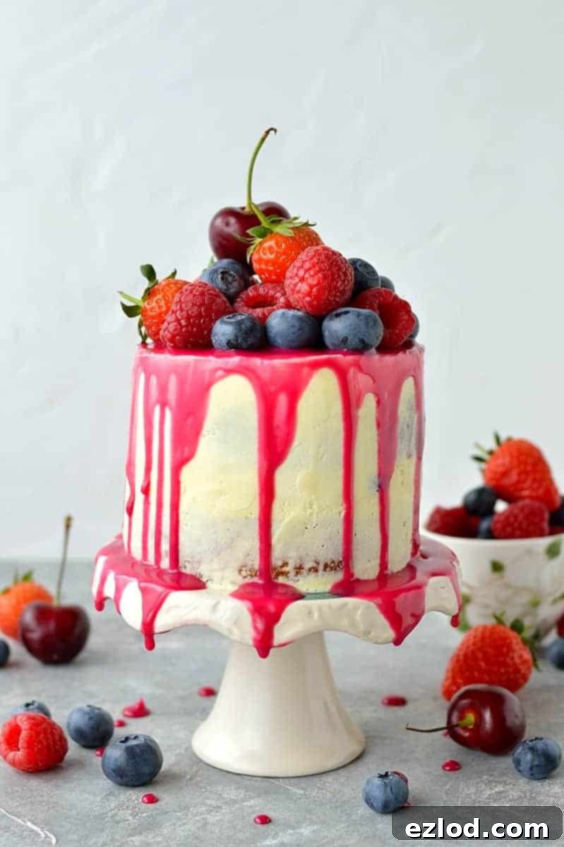 Mini white chocolate berry drip cake - delicious, moist vanilla cake with whipped white chocolate gananche, pink white chocolate drip and fresh berries; serves just 2-4 people!