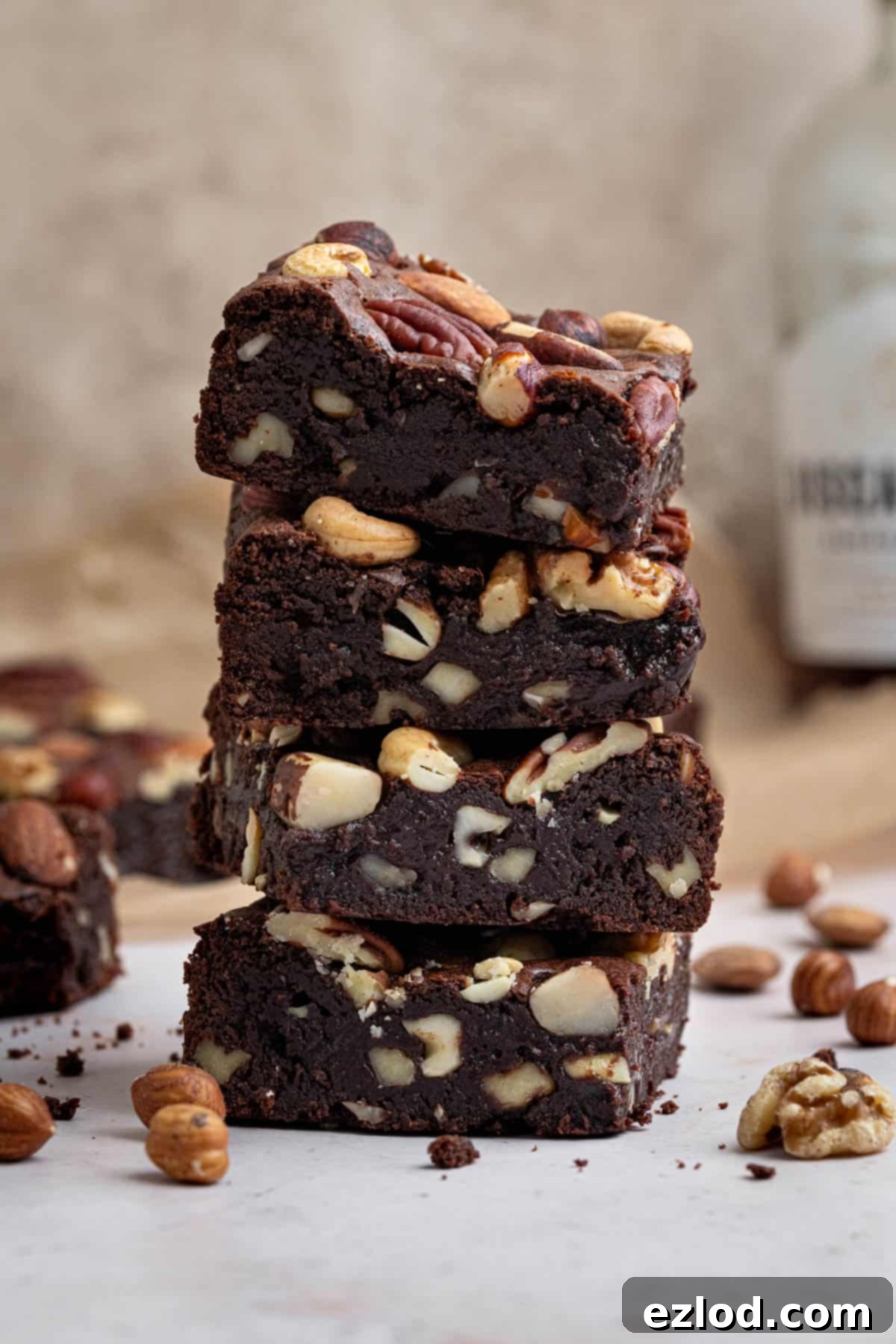Boozy Vegan Nut Brownie Bliss 2 A stack of vegan nutty rum brownies, showcasing their fudgy texture and shiny crust.