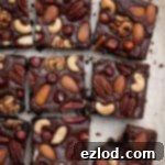 Boozy Vegan Nut Brownie Bliss 12 Sliced vegan nutty rum brownies, one with a bite taken out of it.