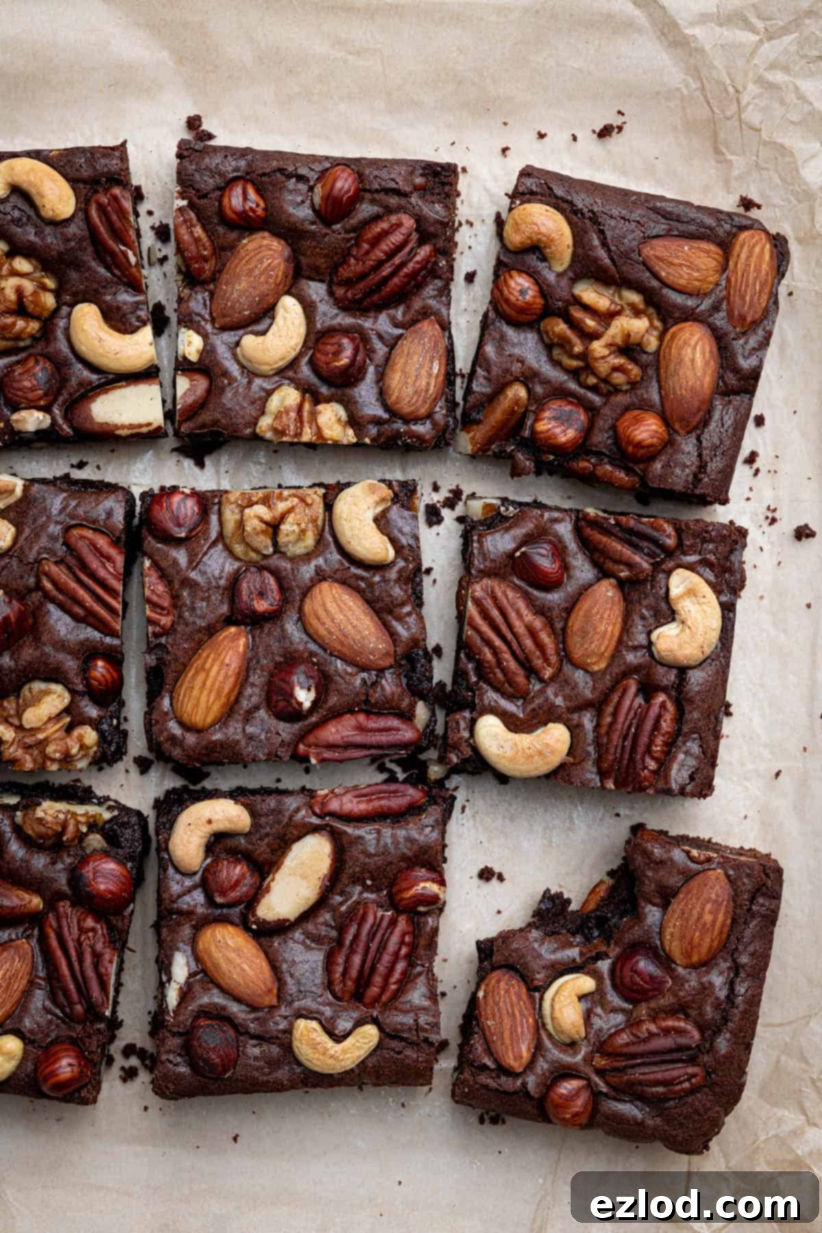 Boozy Vegan Nut Brownie Bliss 4 Perfectly sliced vegan nutty rum brownies, with one piece showing a delicious bite taken out of it.