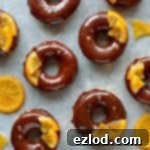 Close-up of chocolate orange doughnuts on a wire rack.