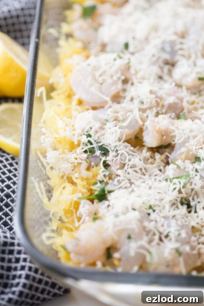 freshly grated parmesan cheese on top of a spaghetti squash casserole, ready for baking