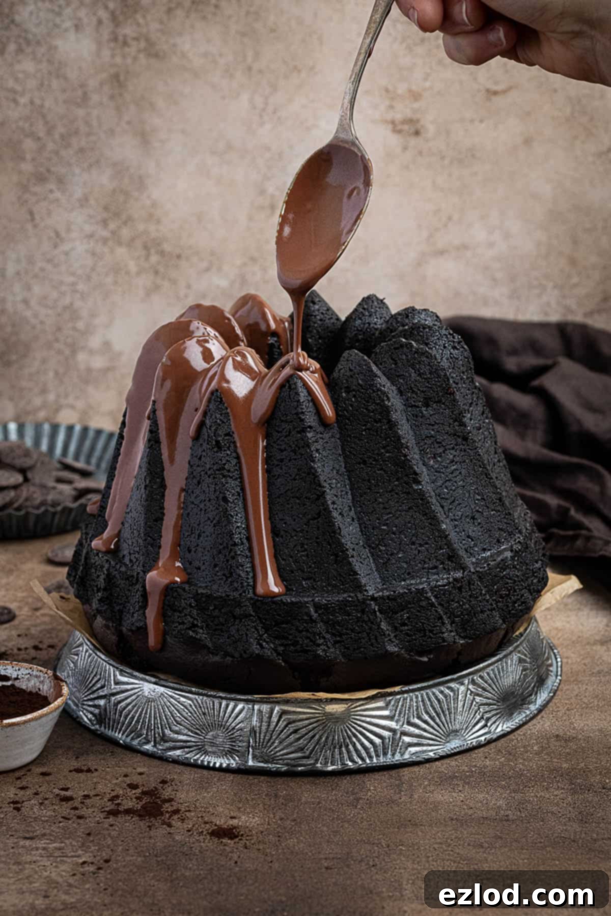 Decadent Vegan Chocolate Bundt Cake 2 A beautifully decorated vegan chocolate bundt cake with luscious chocolate ganache being drizzled on top, highlighting its rich, dark color and moist texture.