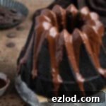 Decadent Vegan Chocolate Bundt Cake 13 Close up of vegan chocolate bundt cake on a metal plate on a brown surface.
