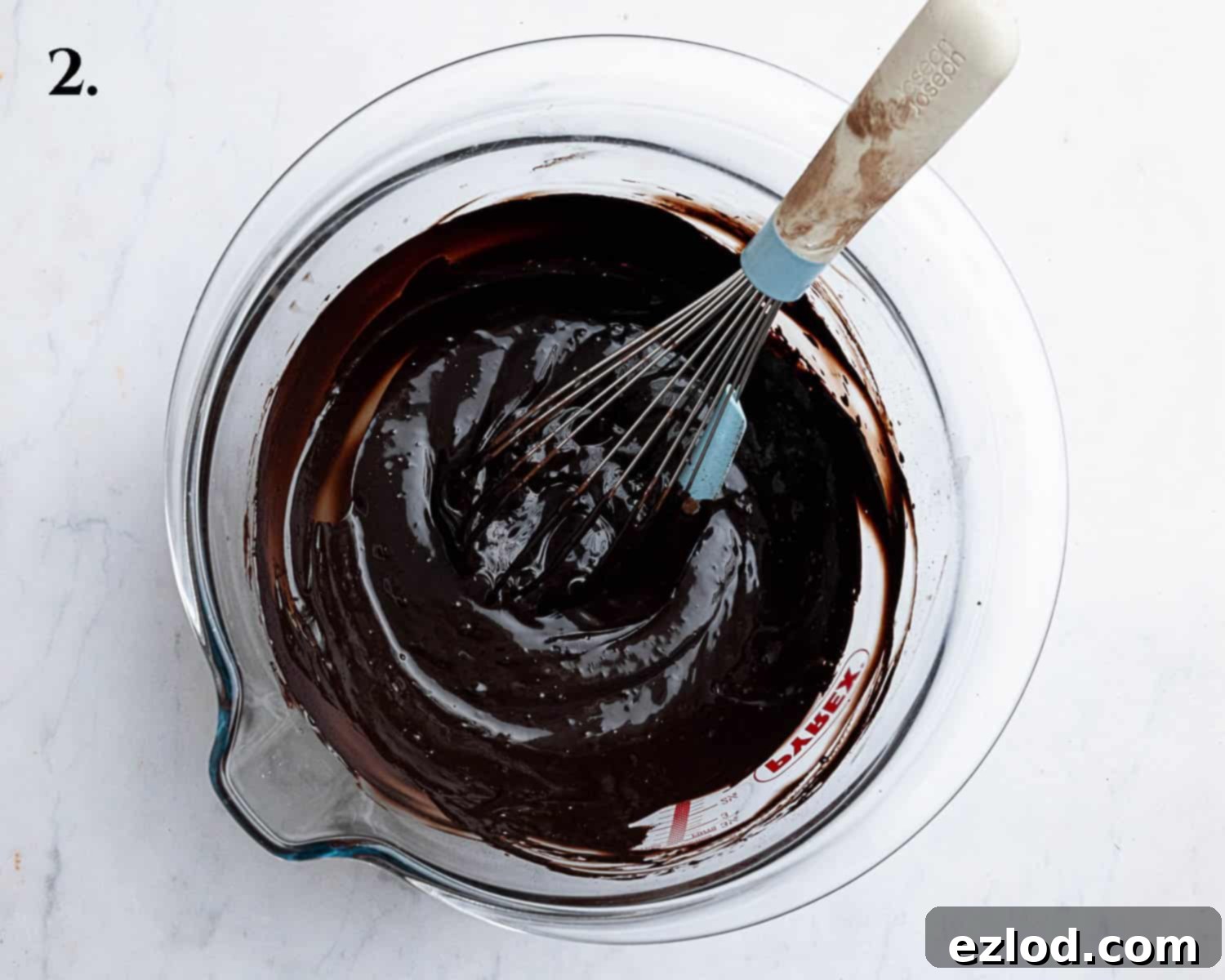 Decadent Vegan Chocolate Bundt Cake 6 Step 2 of the recipe, showing melted dark chocolate mixed with boiling water in a large bowl, ready for the next ingredients.